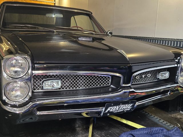 Classic Pontiac GTO, strapped down inside the enclosed trailer
