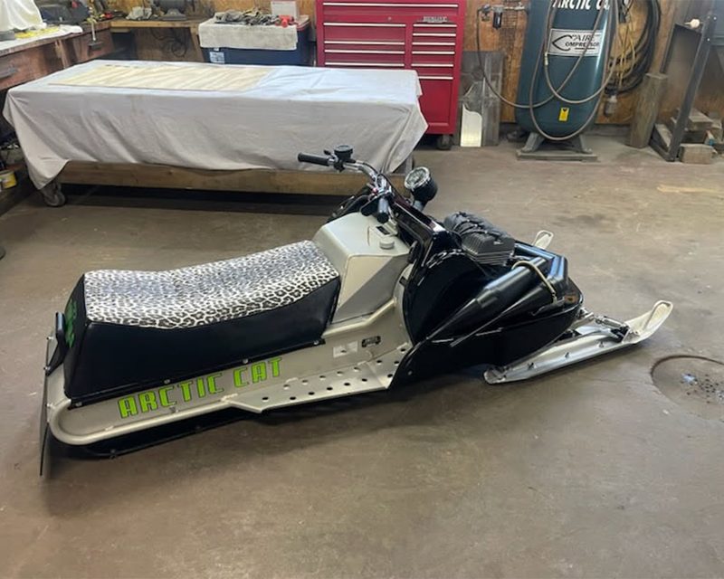 Restored vintage Arctic Cat snowmobile with leopard-print seat