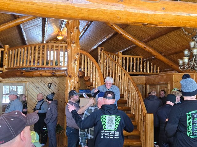Racers and fans packed into a log lodge for a snowmobile racing get-together